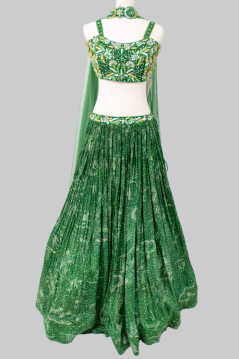 Green traditional outfit with a top and long skirt on a mannequin against a white background