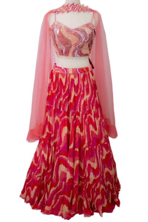 Mannequin wearing a pink and red patterned outfit with a sheer overlay on a white background